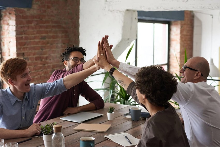 Co-workers high-fiving each other