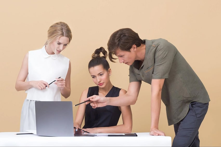 Two colleagues giving feedback to a third person